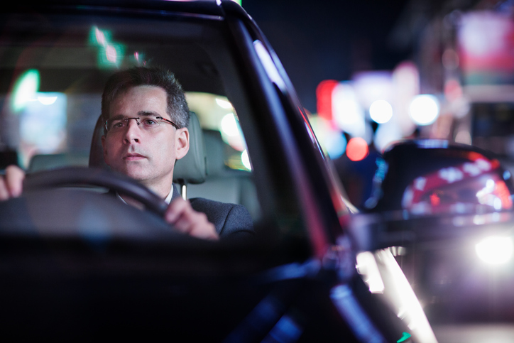 Businessman driving at night in the city
