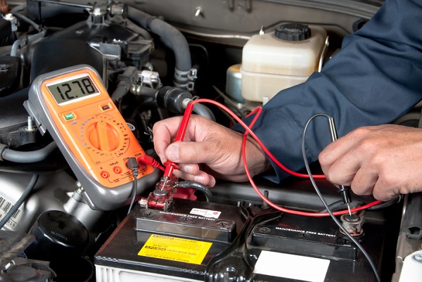 Mechanics use a multimeter during electrical repairs