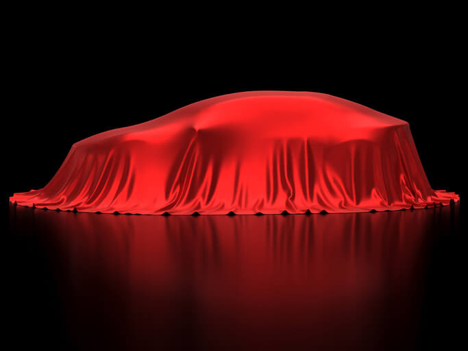 Vehicle covered under a red cloth, ready to be explored by students in automotive training