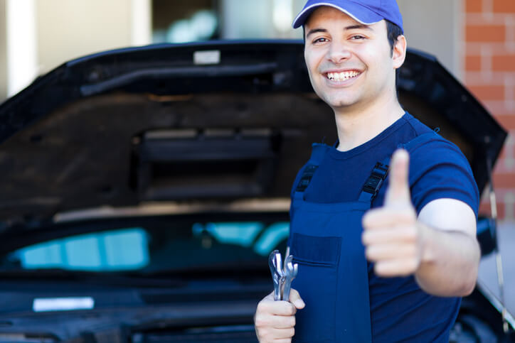 An auto mechanic giving a thumbs-up sign after automotive training