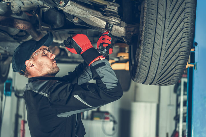 Student in auto estimating training inspecting a car