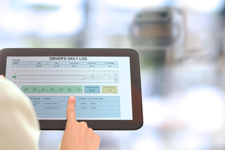 Auto dispatcher holding a driver’s daily log after dispatch training