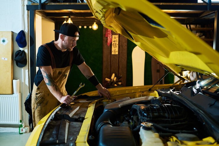 An EV mechanic working on a vehicle after hybrid and electrical mechanic training