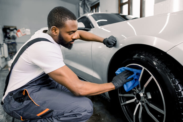 A student in auto detailing training using waterless detailing methods