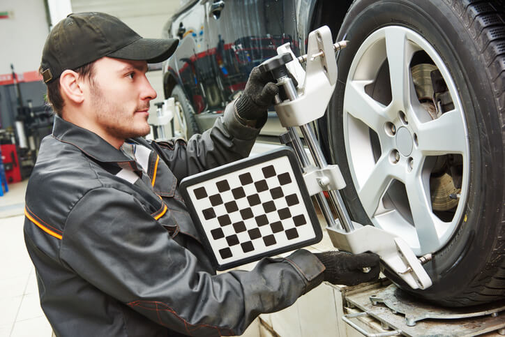 Automotive technology training graduate aligning and replacing the wheel