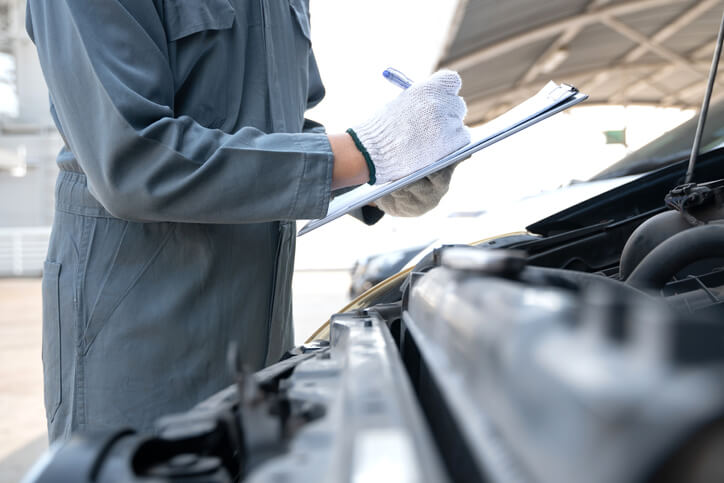 An auto body estimating training grad conducting an inspection and filling out an inspection form.