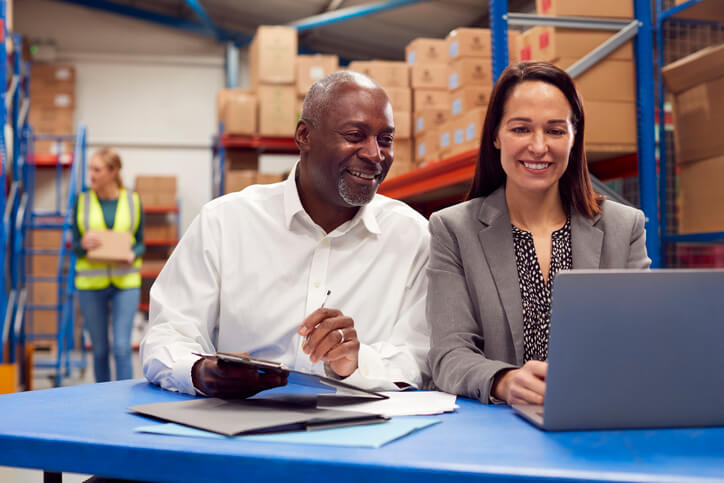 A student receiving dispatch training in a warehouse by a senior industry professional.