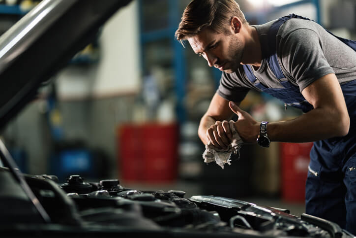 An auto mechanic working on a vehicle after auto mechanic school