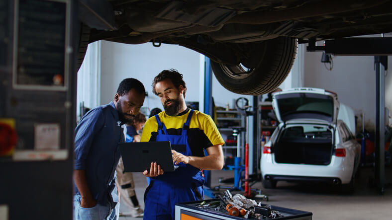 An auto mechanic talking with his supervisor about auto mechanic jobs.