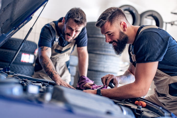 A team of auto mechanic school graduates posing together