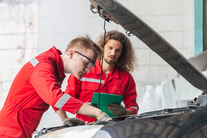 hybrid and electrical mechanic training grads working on a car together