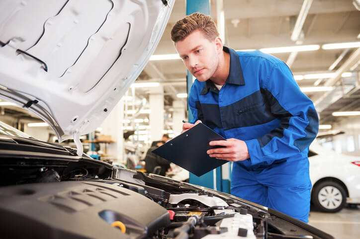 A professional with hybrid and electrical mechanic training inspecting a car