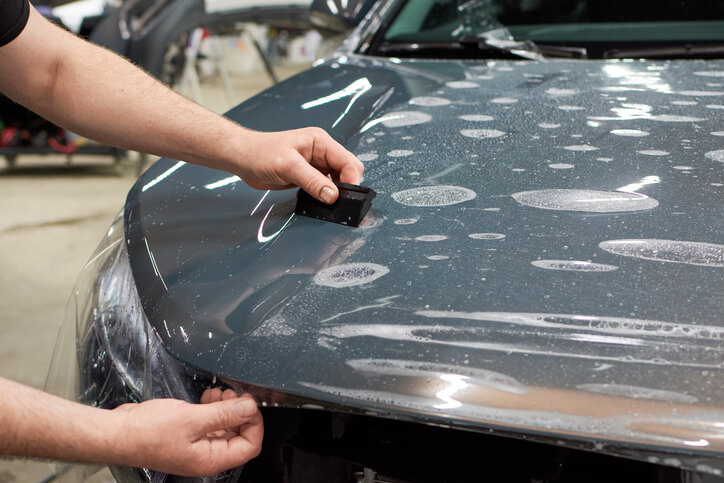 A male auto detailer working on a car’s paint after auto detailing training