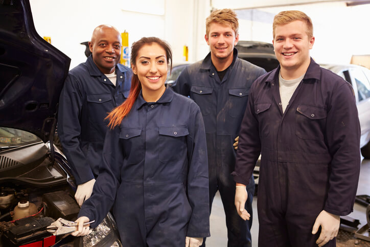 A team of EV mechanics at an auto repair shop after completing their hybrid and electrical mechanic training