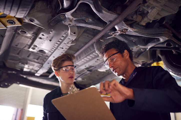 An automotive training grad receiving instruction in a garage