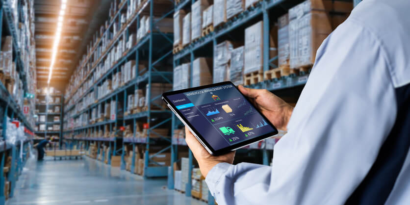 A male dispatch training graduate going through goods in a warehouse