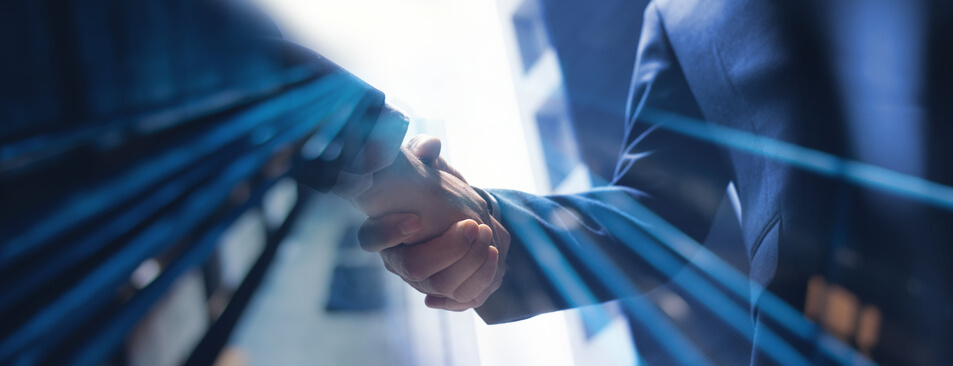 An automotive training grad shaking hands with a business partner