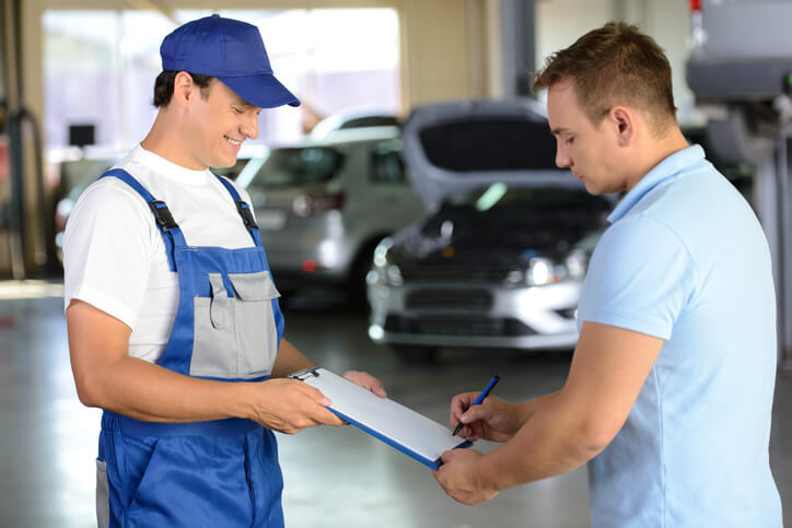 A friendly male auto detailing professional interacting with a customer