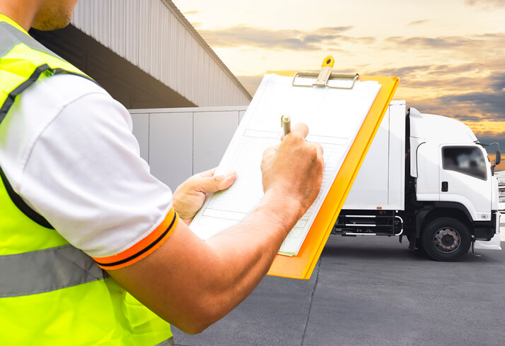 A male dispatcher going through a checklist on a parking lot after completing his dispatch training