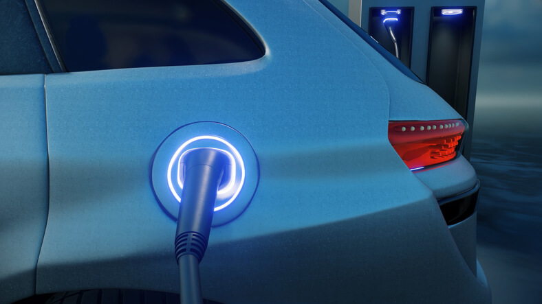 An auto mechanic training grad charging a high-tech EV