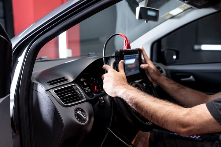 An auto mechanic using a diagnostic scan tool