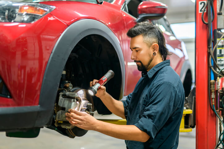 A student at automotive school inspecting a high-performance brake system