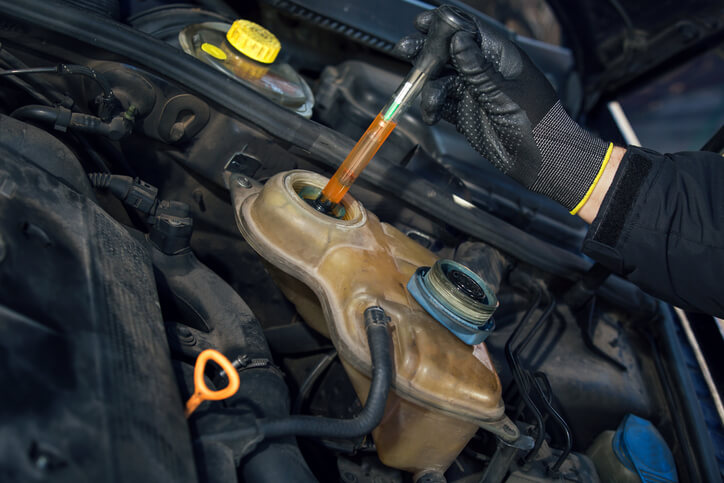 A technician testing coolant levels during engine diagnostics