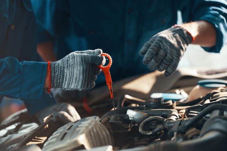 An instructor demonstrating fluid checks during automotive training