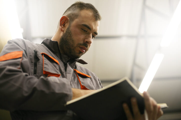 An auto mechanic student reading a vehicle service manual