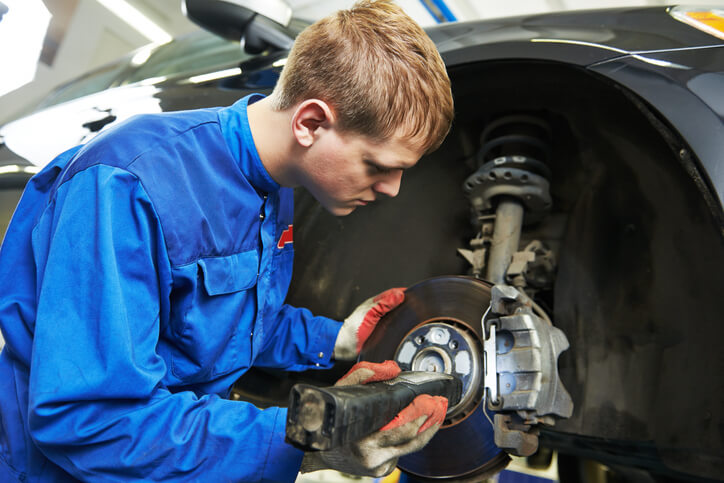 A student at an auto mechanic school inspecting brake rotors