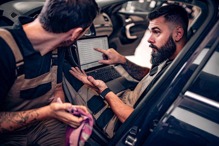 An instructor explaining scan graph patterns to an auto mechanic student