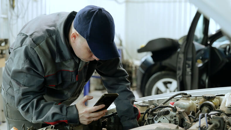 A student learning vehicle diagnostics with a data recorder at ATC Toronto