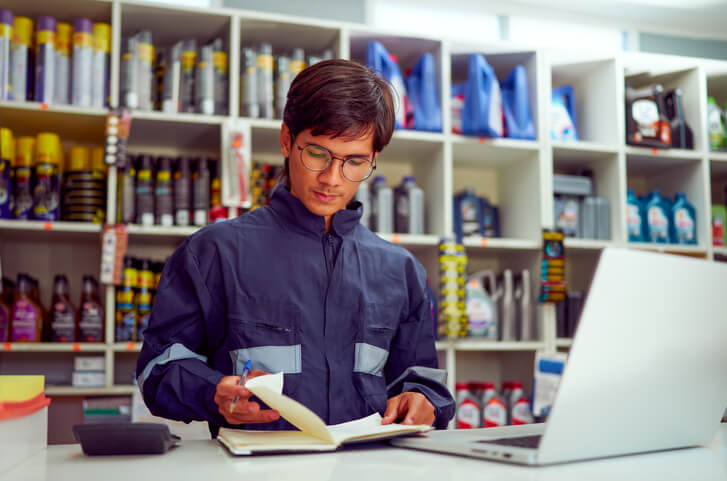 An auto mechanic student in ATC Cambridge reading a service bulletin