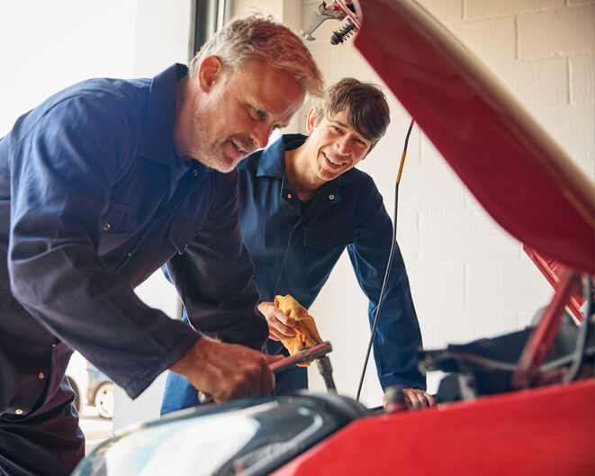 An automotive school student learning diagnostics with an instructor