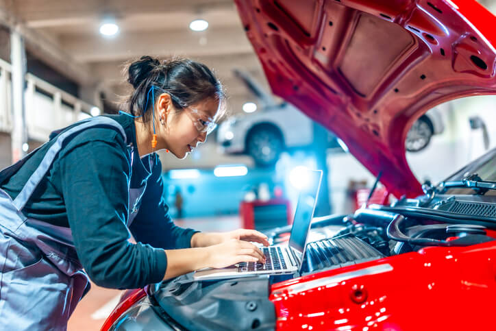 An auto mechanic school student using diagnostic tools