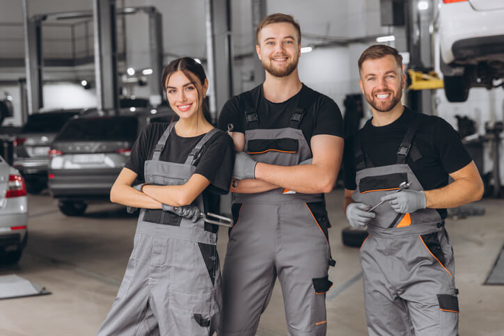 A row of auto mechanic school students standing confidently in a row