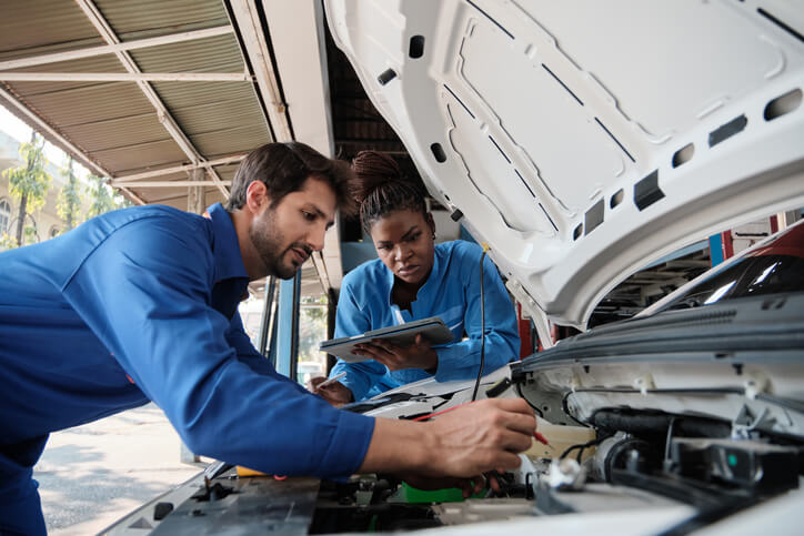 A student learning auto diagnostics in an auto mechanic school lab