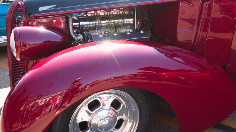 A comparison of car surfaces protected with wax versus ceramic coating, showing different levels of gloss.