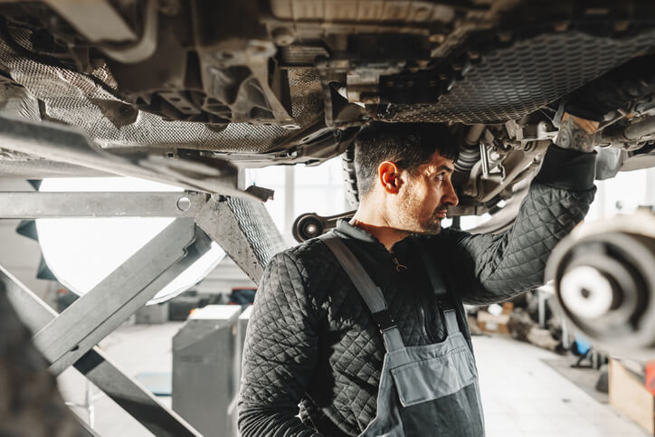Auto mechanic performing maintenance on an AWD vehicle