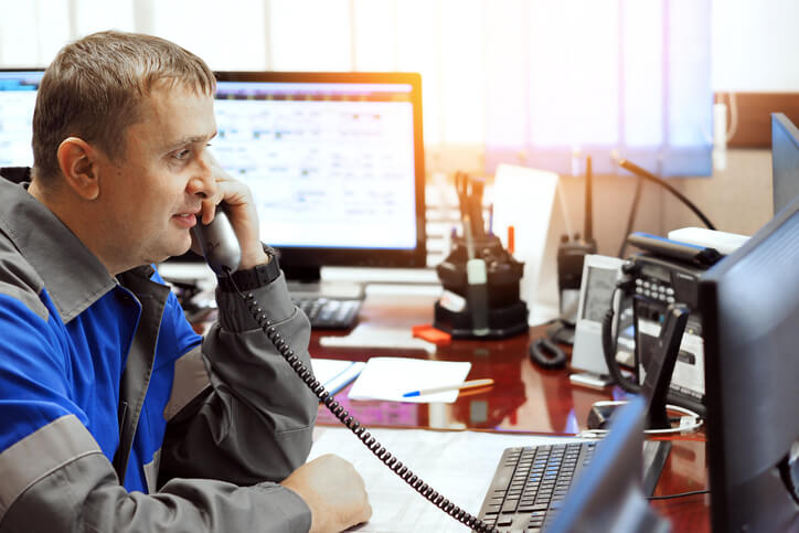 A fleet dispatcher using logistics software on a computer