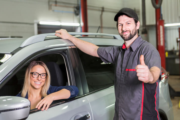 An auto repair shop business manager training graduate reviewing invoices