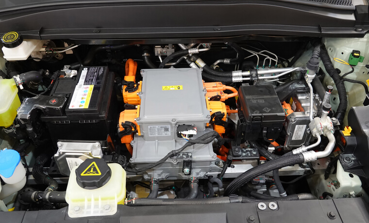 An automotive school student inspecting an EV battery module during auto mechanic training