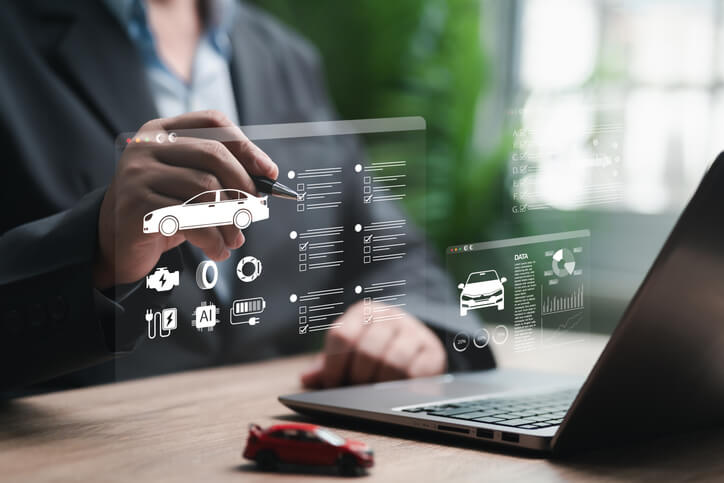 An automotive professional reviewing AI-powered vehicle diagnostic analytics on a tablet.