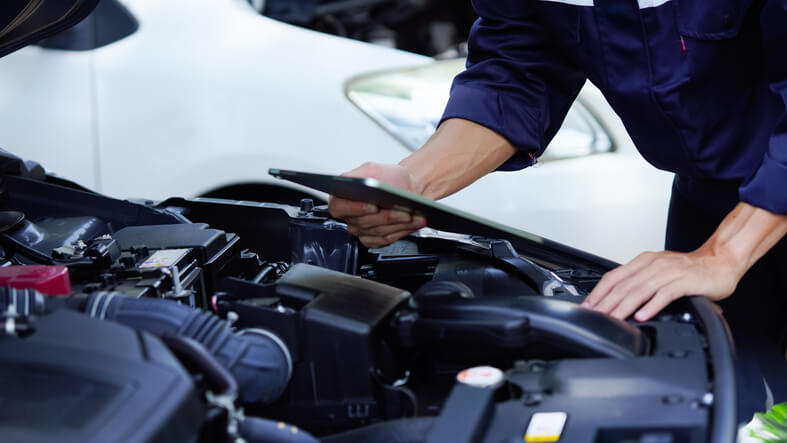 An apprentice mechanic learning to use diagnostic tools in the shop