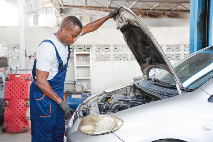 A mechanic examining brake and steering parts in a car
