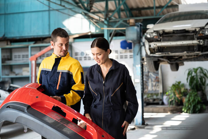 An instructor guiding a student through collision frame repair
