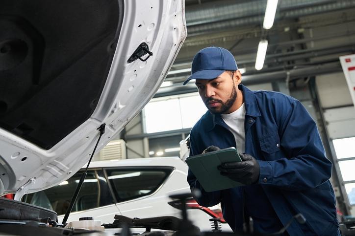 An auto mechanic school student testing battery performance before winter