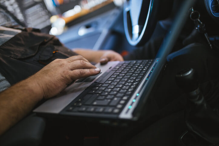 A laptop connected to a vehicle’s onboard diagnostic system
