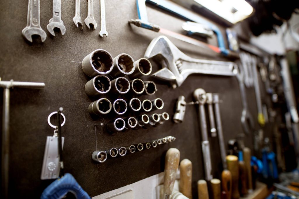 A close-up view of an organized mechanic's tools on a workshop wall, demonstrating the clean workspace emphasized in auto mechanic training.