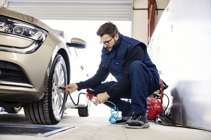 A technician checking tire pressure during hands-on auto mechanic training